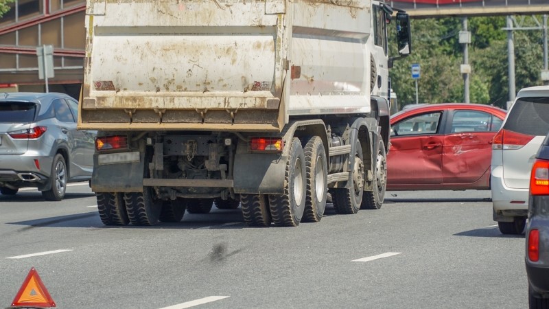 Accident of a truck and car on a large urban multi-lane road.