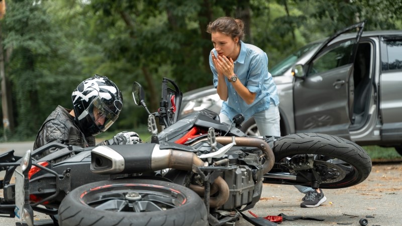 Collision between motorcycle and car on the road.