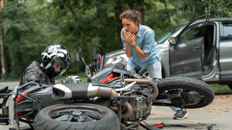 Collision between motorcycle and car on the road.