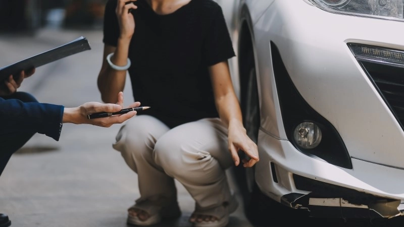 A young businesswoman is navigating car insurance options at her desk,