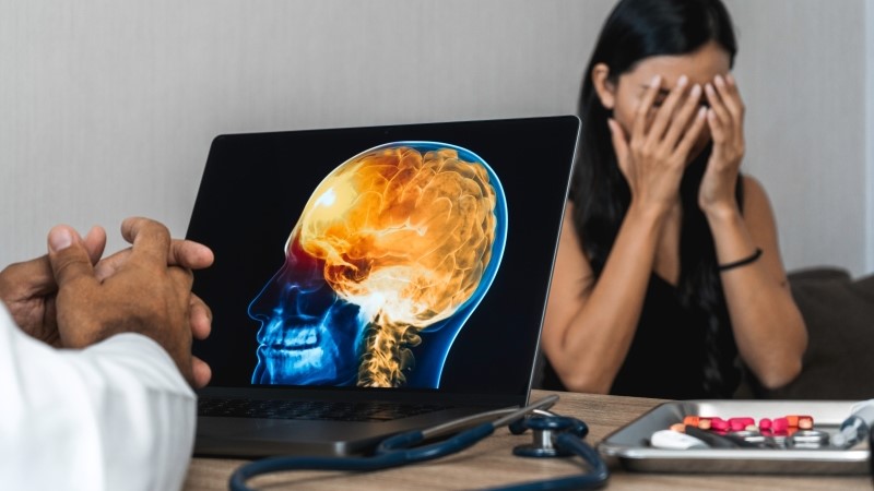 Doctor showing a x-ray of pain in the brain on a laptop.