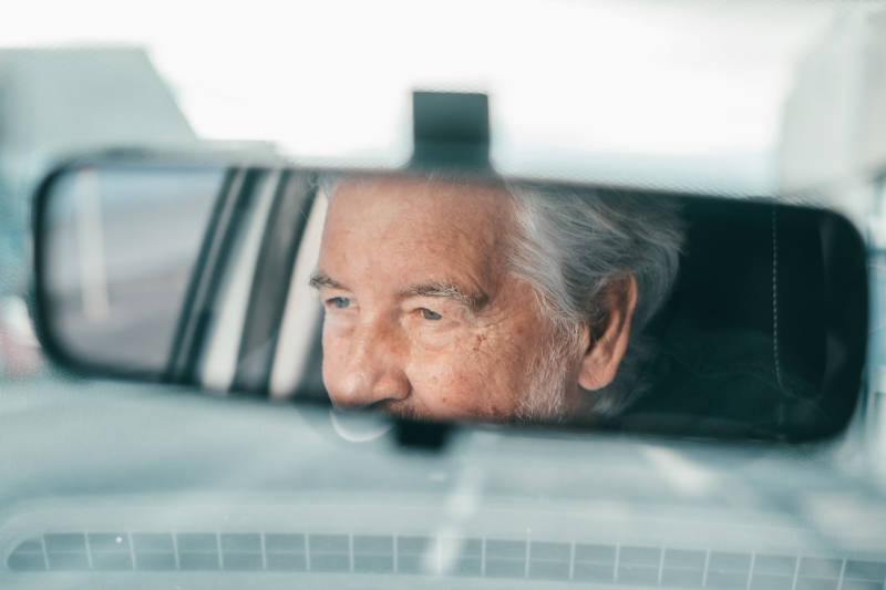 Portrait of one old pensioner man driving and enjoying his new car.