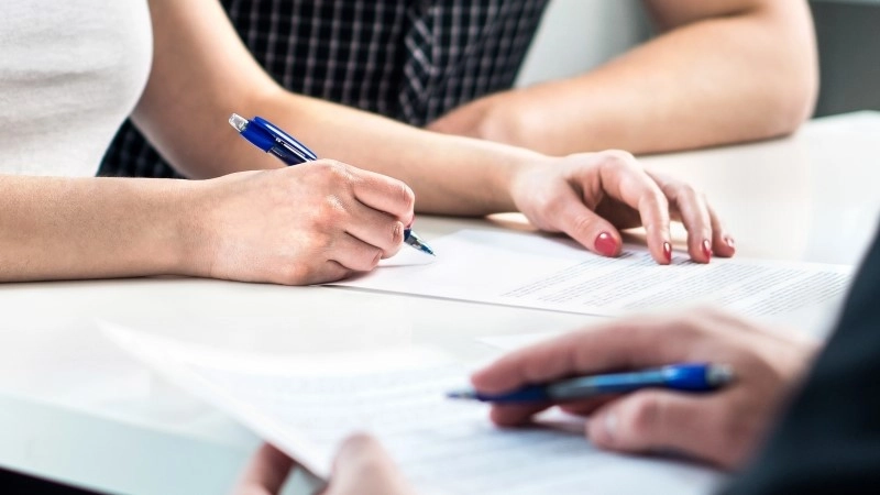 Settlement document signing. Bank loan contract or health insurance paper. Family paperwork. Home buyer debt or business agreement.