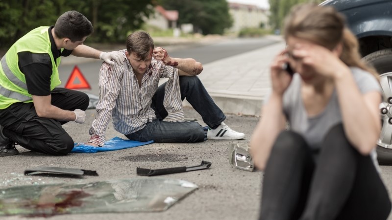 People sitting on the road after car crash