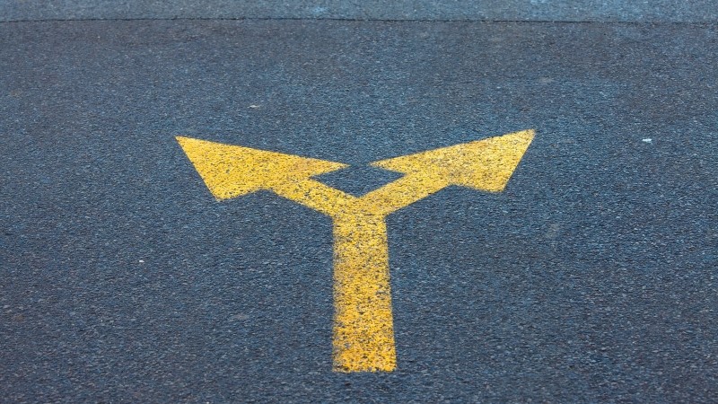 Arrow sign on the asphalt road