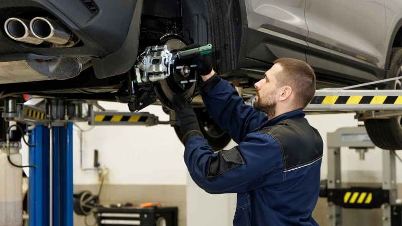 Brake pad repair, car on a lift, close-up. A modern car in a car service on a lift with a wheel removed.