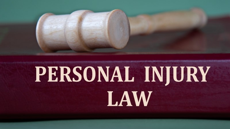PERSONAL INJURY LAW - words on a burgundy folder on the background of a judge's gavel