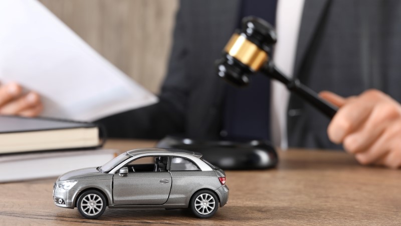 Auto accident law. Man with document and gavel at wooden table indoors,