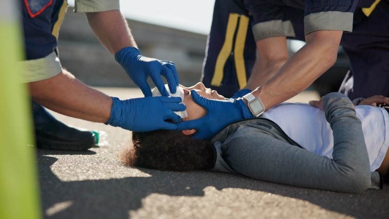 EMS, wrapping bandage or first responder with victim or rescue in street for transport to hospital