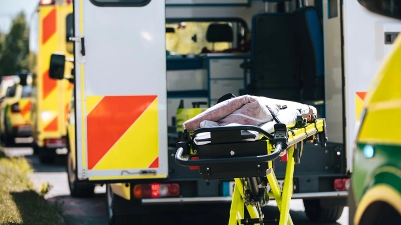 Stretcher prepared behind open ambulance.