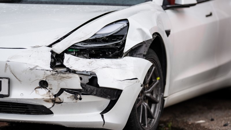 Crashed white electric car waiting for repair