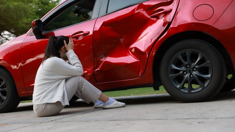Female Driver Involved in Car Accident, Calling for Insurance Assistance.