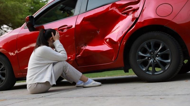 Female Driver Involved in Car Accident, Calling for Insurance Assistance.