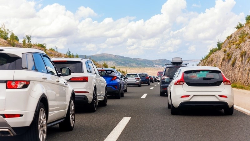 Back tail view of many cars stuck in row at highway road