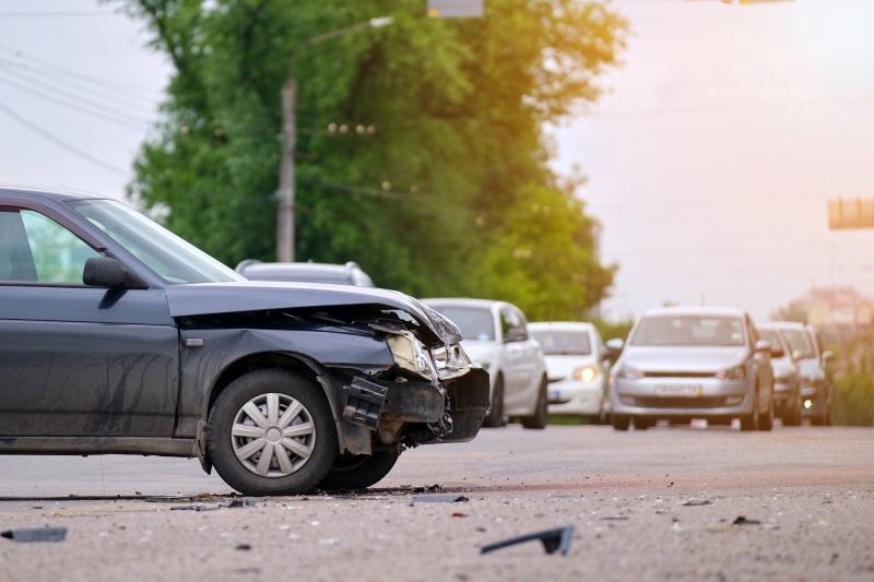 Damaged in car accident vehicle on city street crash site.