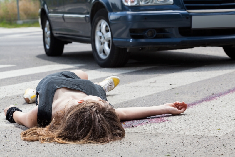 Dead woman lying on a street after road accident