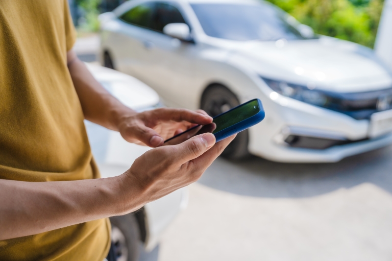 Man fills out a car insurance form after a car accident.