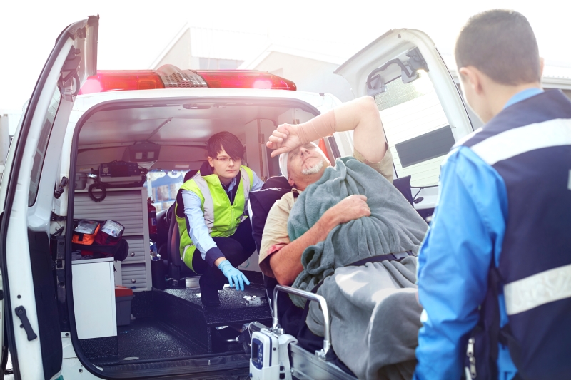 Rescue workers loading car accident victim into back of ambulance