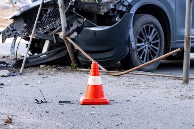 road cone against the background of a car broken in a road accident.