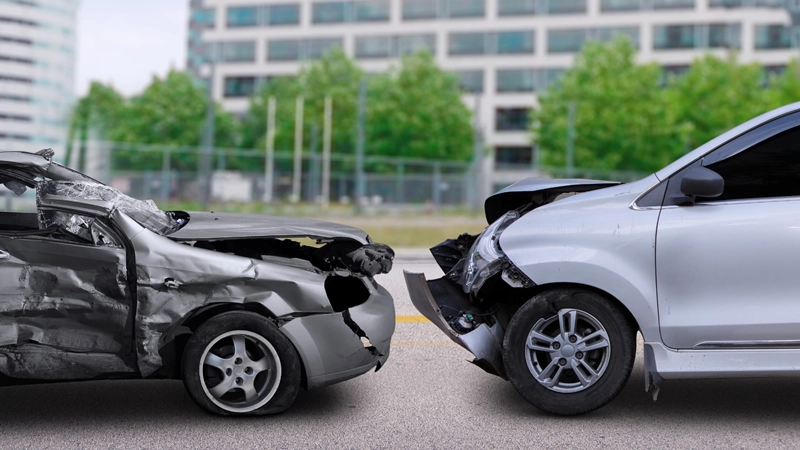 Two damaged cars with crushed front ends after serious collision on roadway