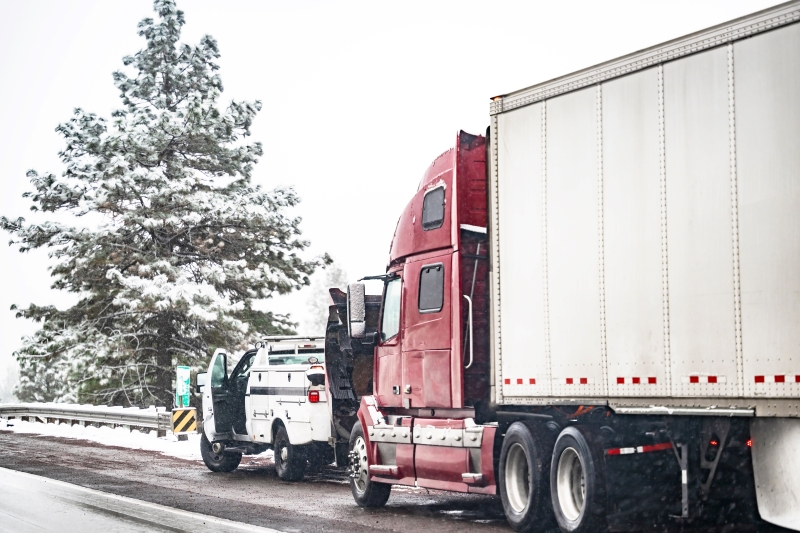 Broken big rig semi truck with open hood and semi trailer standing out of service