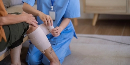 Nurse Bandaging Dog Bite Wound on Patient Leg Bend Oregon